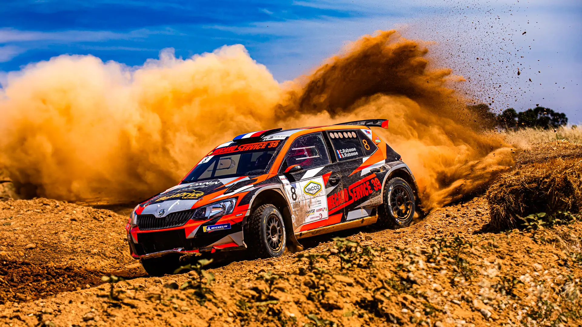 Voiture de rallye en pleine dérive sur la terre, gerbe de poussière